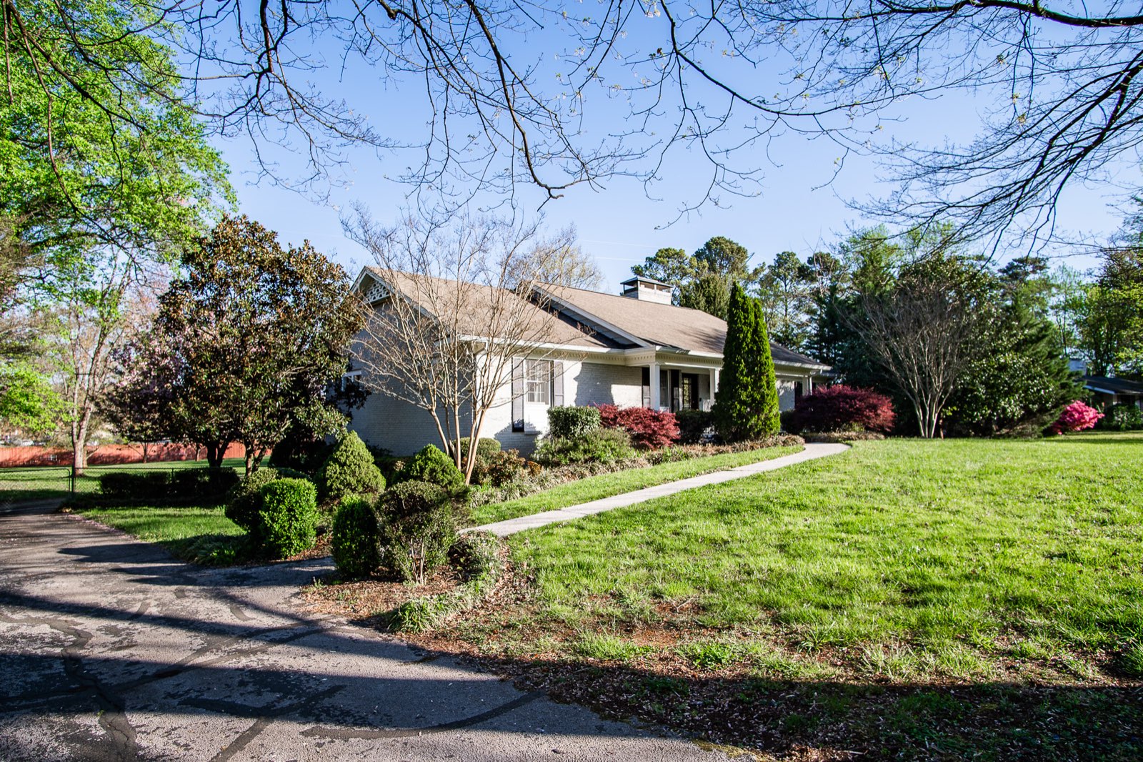 Brick ranch rental home with a big front lawn in spring